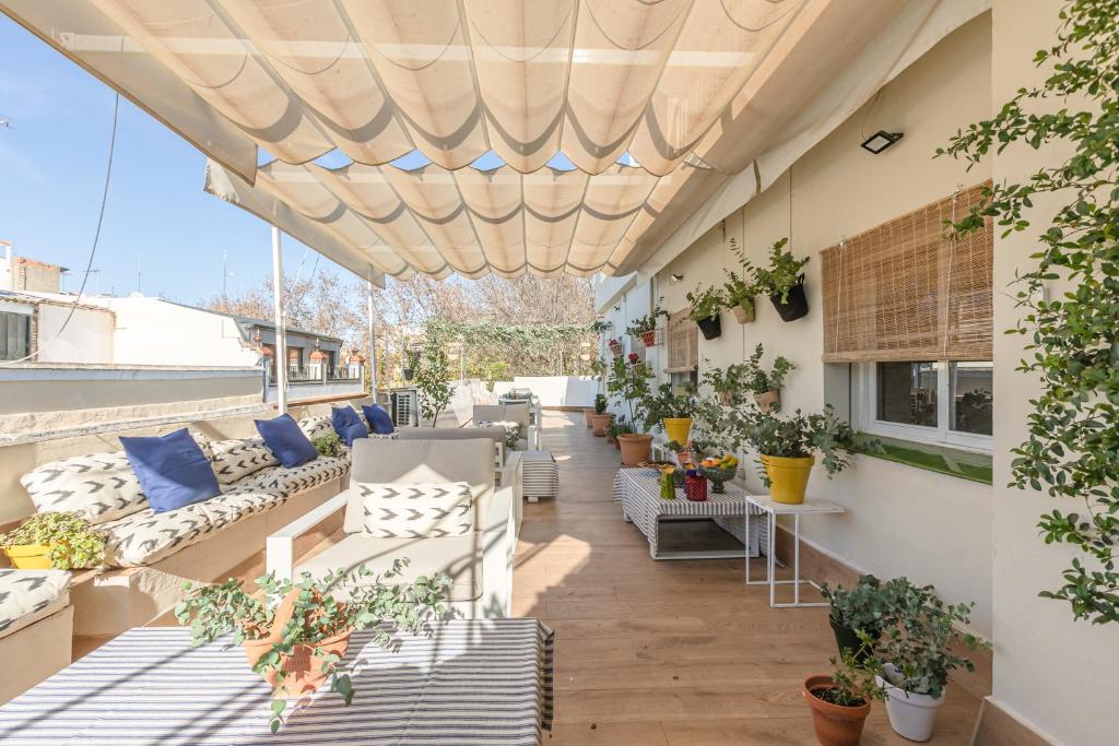 um pátio exterior com sofás e plantas em Jardin de la Alameda Hostal Boutique em Sevilha