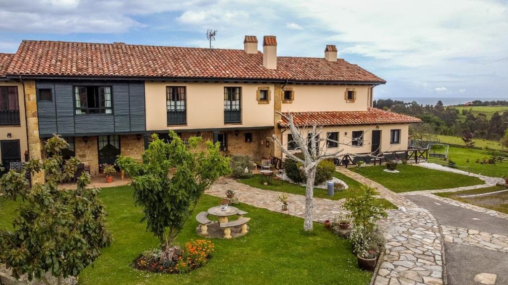 una imagen de una casa con jardín en Hotel Rural La Figar, en Argüero