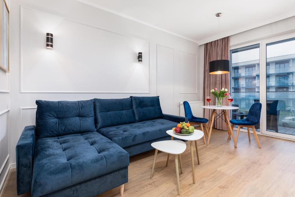 a living room with a blue couch and chairs at Wellness Resort & SPA Apartments Dziwnów Riverfront by Renters in Dziwnów