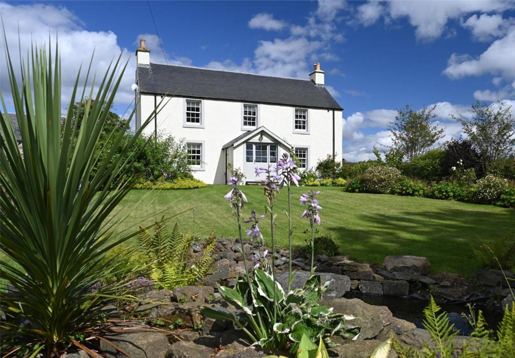 une maison blanche avec un jardin en face dans l'établissement Laverockbank Farmhouse, à Perth