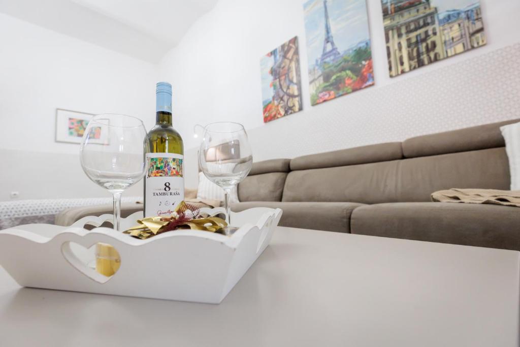 Una botella de vino y dos copas en una mesa en Apartments Pia, en Subotica