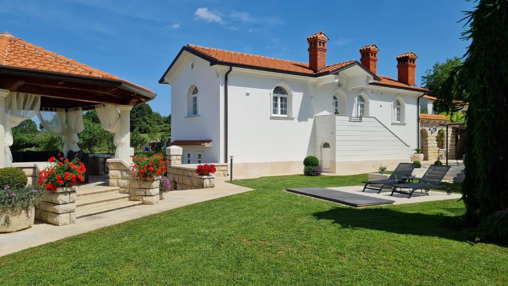 a large white house with a bench in a yard at Holiday Apartment VILLA BIANCA in Pazin