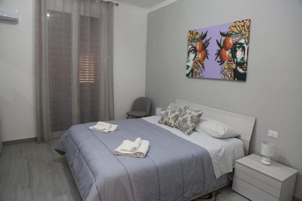een slaapkamer met een bed met twee handdoeken erop bij Camurría Sicily home in Montelepre