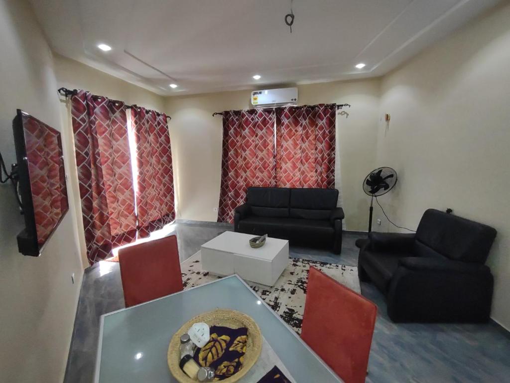 ein Wohnzimmer mit einem Sofa, einem Tisch und Stühlen in der Unterkunft Villa N'KOMI in Lomé