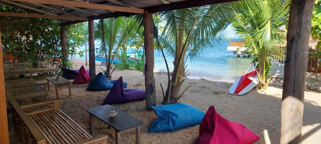 a beach with colorful pillows on the sand at Arto Moro Bunaken in Bunaken