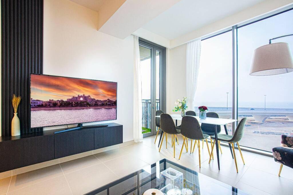 a living room with a tv and a table with chairs at Stylish 1 Bedroom in 5242 by Ofex in Dubai