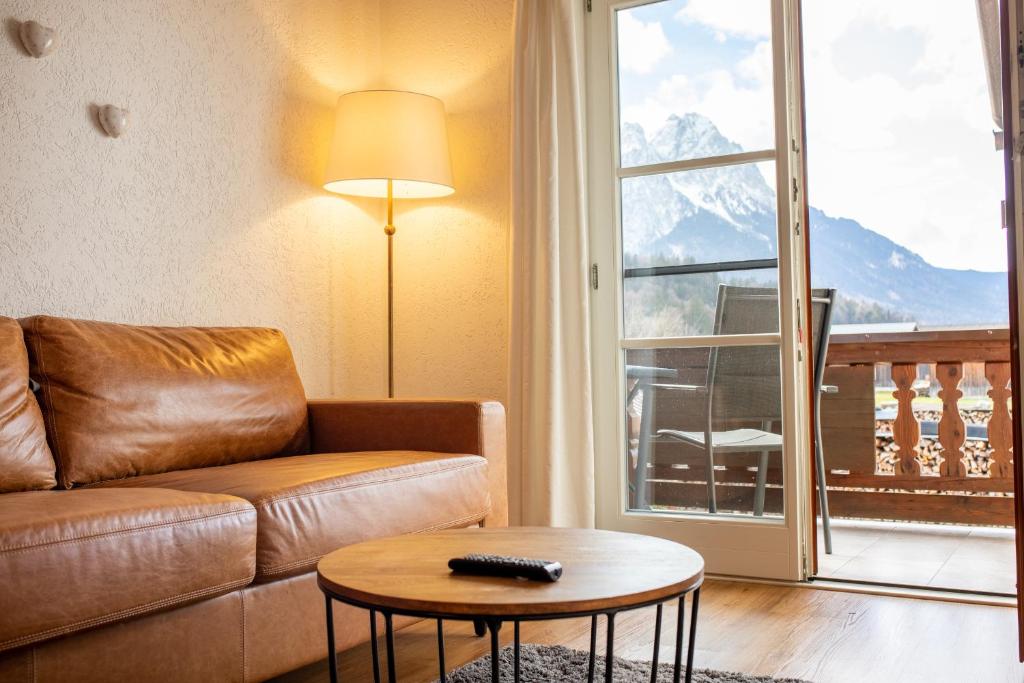 sala de estar con sofá y mesa en kloana Waxlstoa, en Garmisch-Partenkirchen