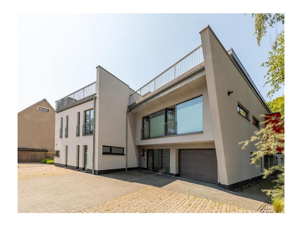 a large white house with a driveway at Suite-Meerblick-Juliusruh in Juliusruh