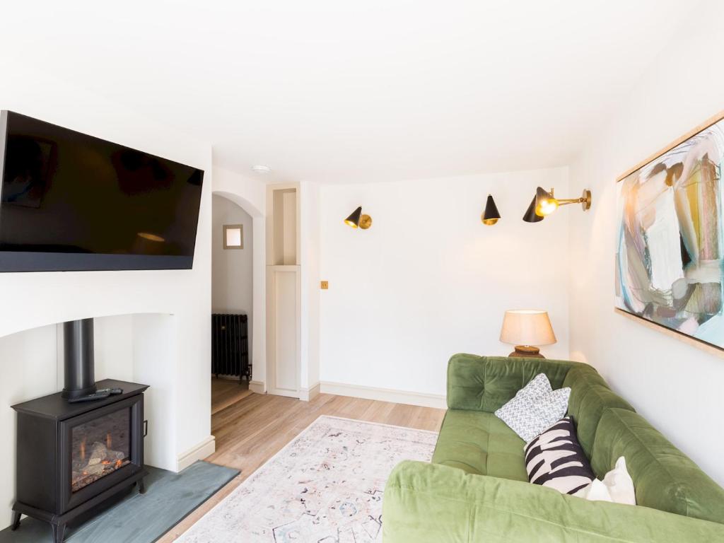 a living room with a green couch and a flat screen tv at Pass the Keys Central Stratford upon Avon Super Stylish 1Bed in Stratford-upon-Avon