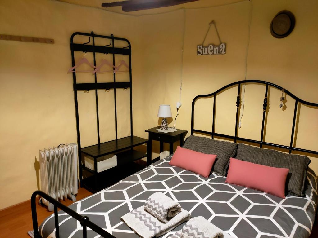una camera da letto con un letto bianco e nero con cuscini rosa di Casa Rural Bella Culla a Culla