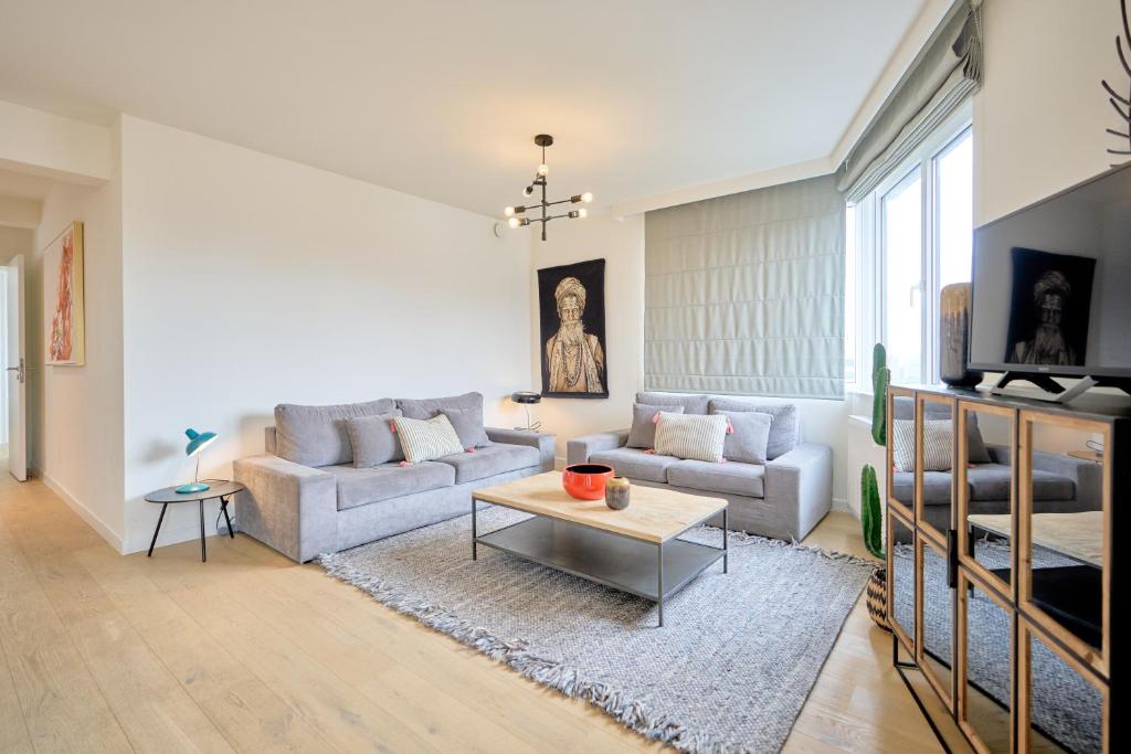 a living room with a couch and a table at Diamant 3 Bedroom in Brussels