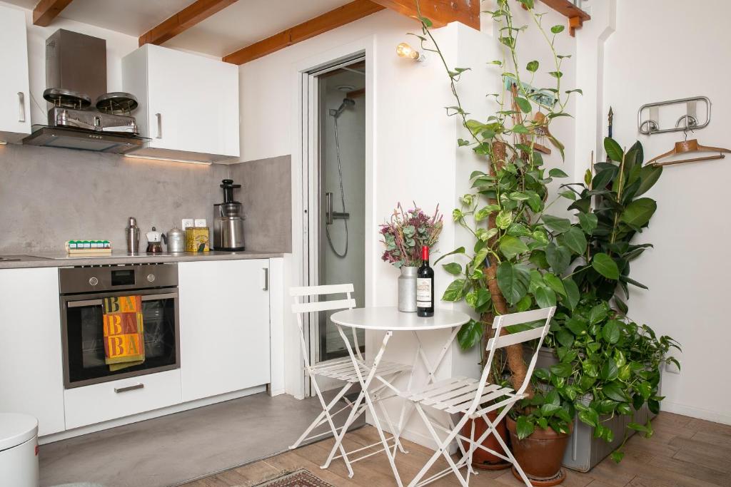 une cuisine avec une table, des chaises et des plantes dans l'établissement Cosy Studio !!!, à Paris