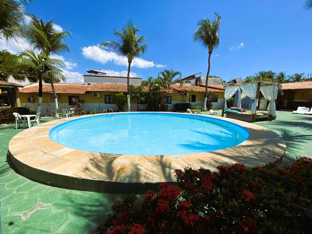 uma grande piscina num quintal com palmeiras em Pousada Hippopotamus Jeri em Jericoacoara
