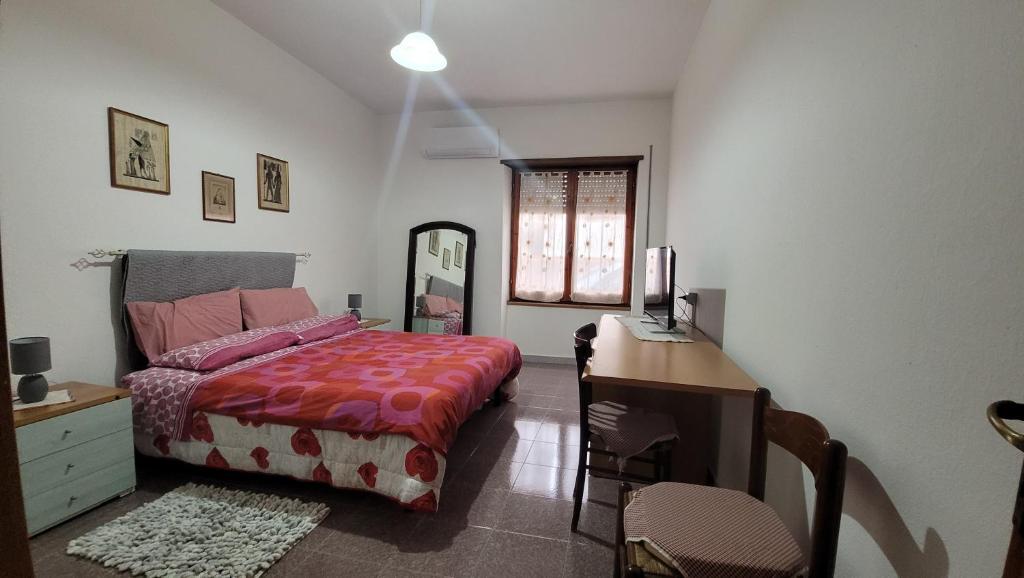1 dormitorio con 1 cama y escritorio con ordenador en Holiday Maria Luisa, en Galtellì
