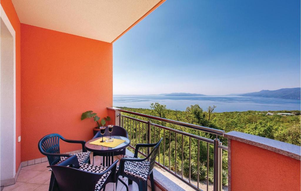 a balcony with a table and chairs and a view of the ocean at Stunning Apartment In Kastav With House Sea View in Kastav