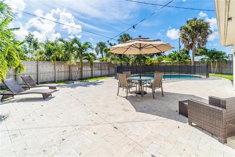 a patio with a table and chairs and an umbrella at Home Wpool By Pmi Unit Dfs in Deerfield Beach