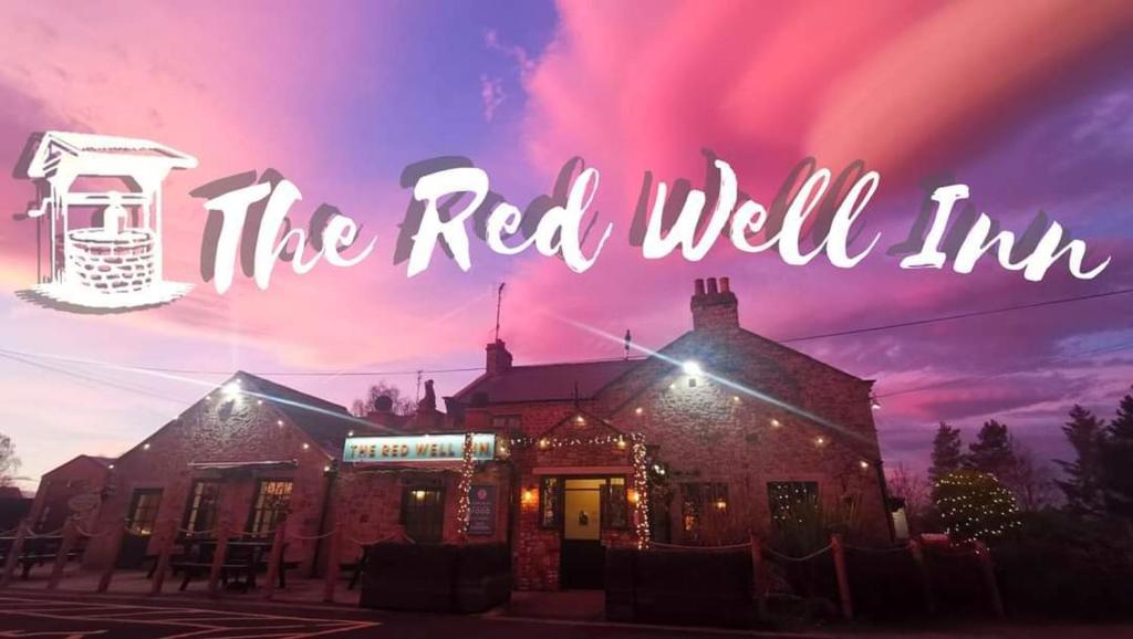 ein roter Brunnen Gasthof mit einem rosa Himmel im Hintergrund in der Unterkunft The Redwell Inn in Barnard Castle