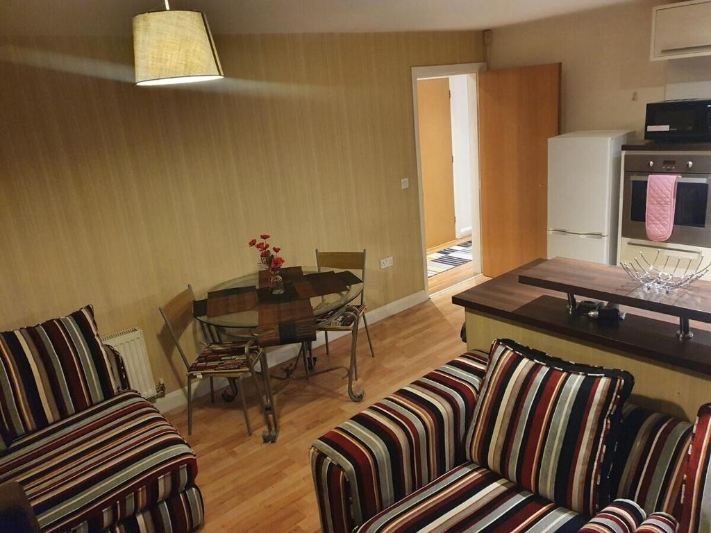 Il comprend un salon avec deux chaises et une table ainsi qu'une cuisine. dans l'établissement Two Bedroom Apartment, Free parking, Close to UCLAN and free WIFI, à Preston