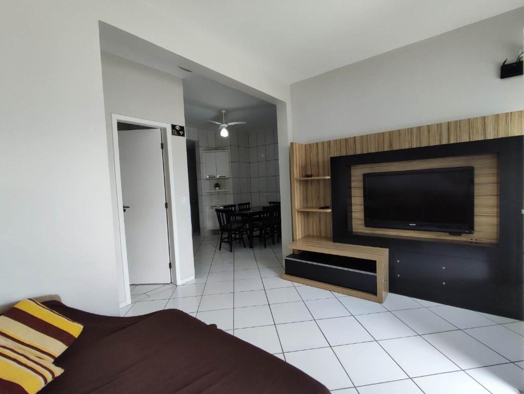 a living room with a flat screen tv on a wall at APARTAMENTO ESTRELA DO MAR A 1 QUADRA DO MAR in Guaratuba