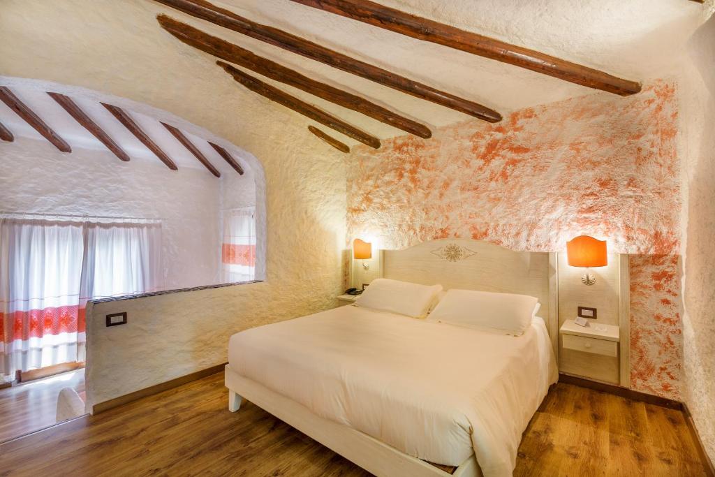 a bedroom with a white bed and a window at Hotel Don Diego in Porto San Paolo