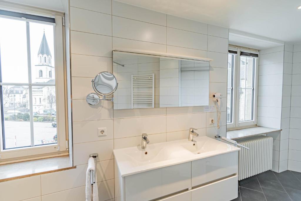 a bathroom with a sink and a mirror at Hotel Herckmans in Ettelbruck