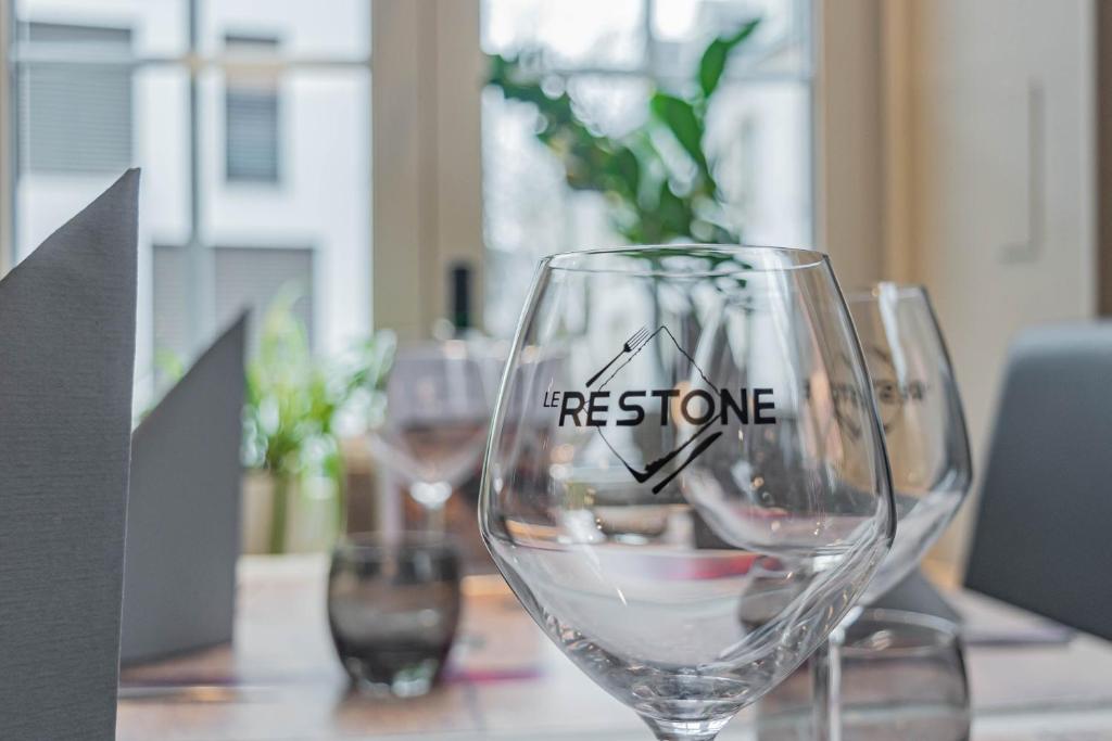 a wine glass with the worditance written on it on a table at Hotel Herckmans in Ettelbruck