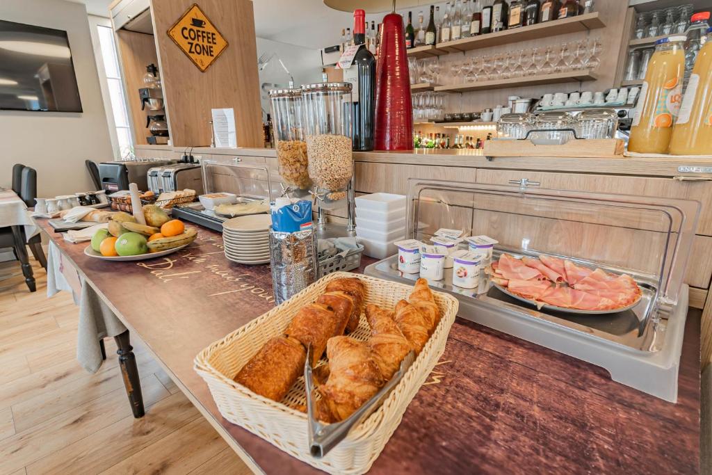a bakery with a table with bread and other foods at Hotel Herckmans in Ettelbruck