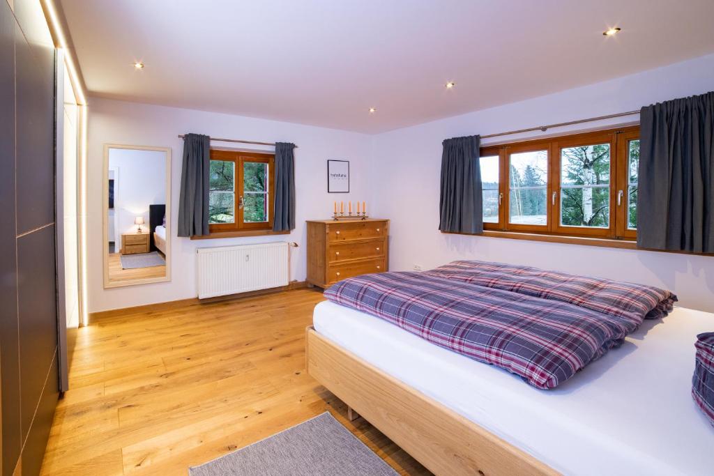 a bedroom with a bed and a dresser and windows at RACHEL BASECAMP in Spiegelau