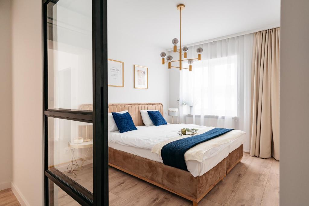 a bedroom with a bed with blue pillows at Crystal House II - LoftAffair Collection in Kraków