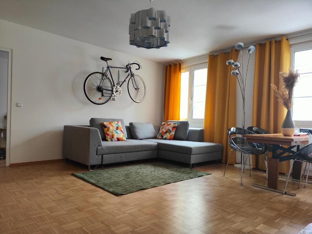 a living room with a couch and a bike hanging on the wall at LOLLIPOP - metro to the opera 4 mins away in Vienna