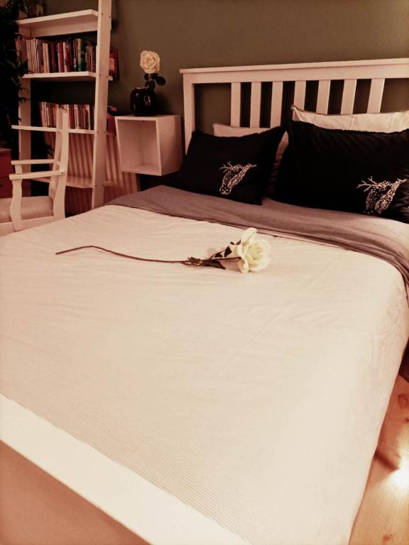 - un grand lit blanc avec une fleur blanche dans l'établissement la belle evasion Paris, à Paris