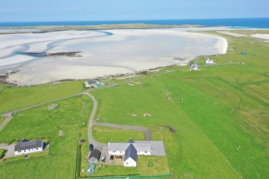 een luchtzicht op een boerderij en de oceaan bij Vallay Sands in Sollas