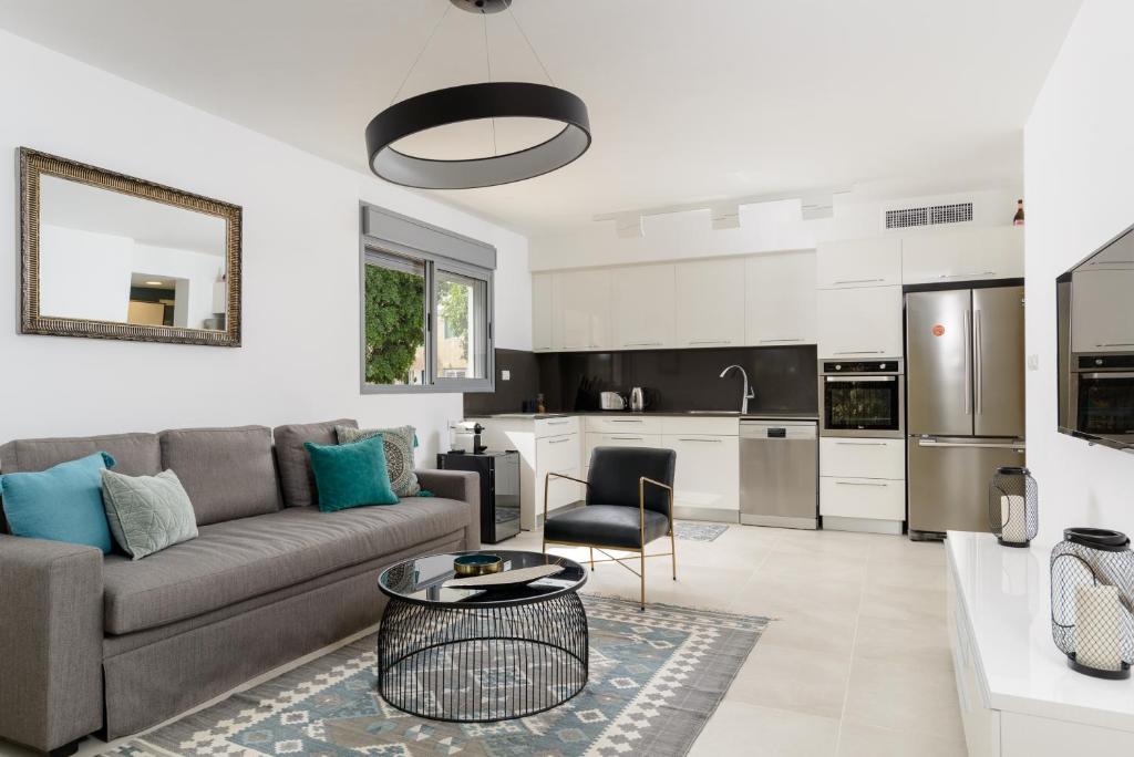 a living room with a couch and a kitchen at Sienna Sky by HolyGuest in Tel Aviv