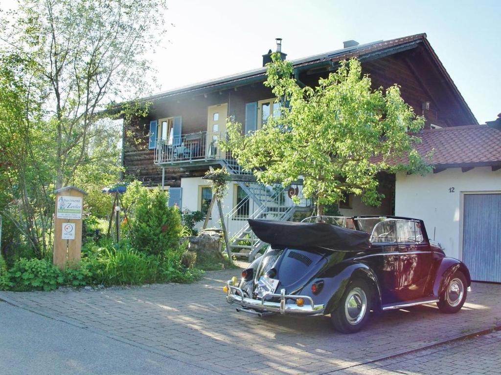 ein altes Auto, das vor einem Haus parkt in der Unterkunft Apartment Zettler in Buxheim