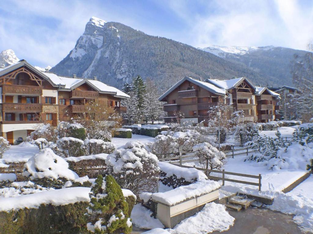 un lodge dans la neige avec une montagne en arrière-plan dans l'établissement Studio cosy au centre de Samoëns avec parking privatif - FR-1-629-118, à Samoëns