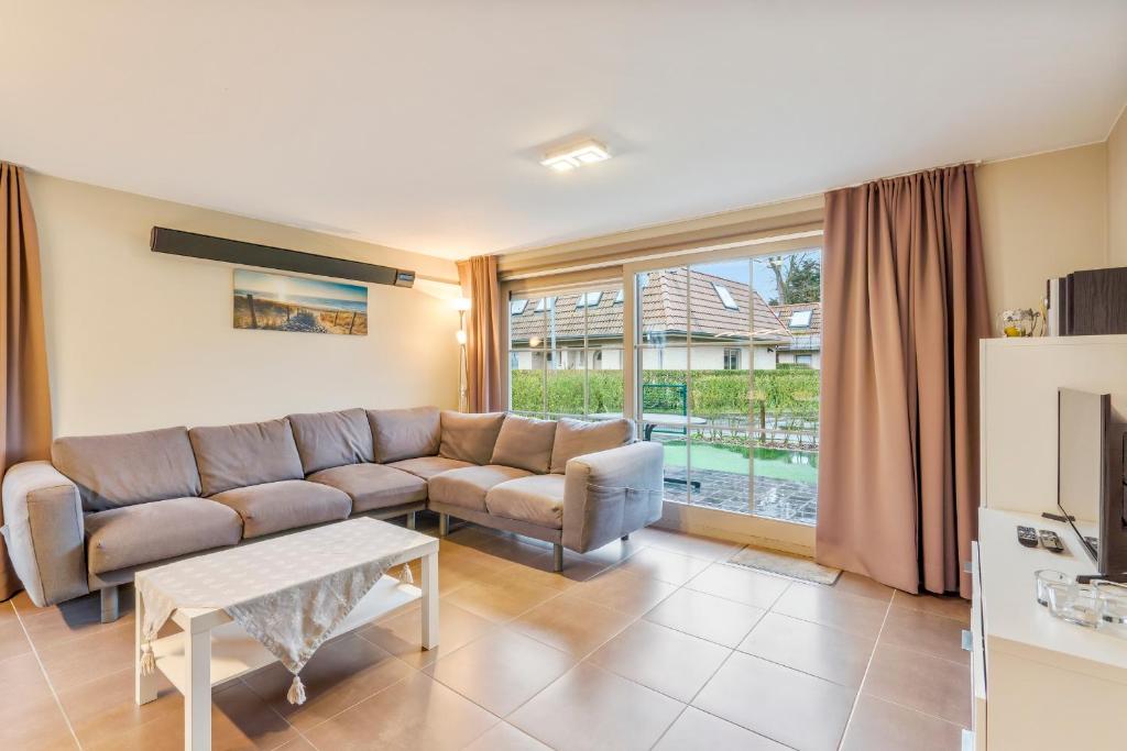 a living room with a couch and a table at Casa Kids in De Panne