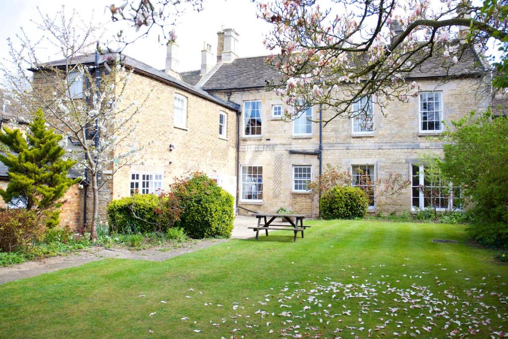 an old stone house with a picnic table in the yard at Garden House Stamford in Stamford