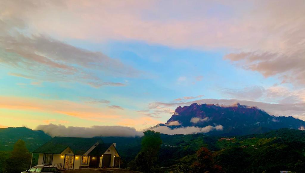 a house on a hill with a mountain in the background at Hounon White Chimney Cottage-4 Bedrooms in Ranau