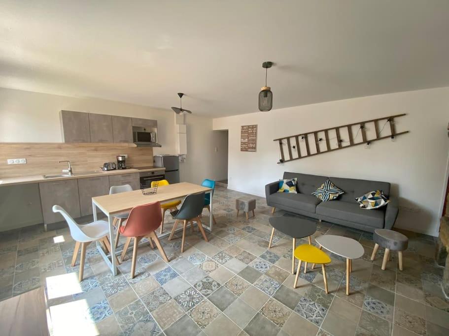 un salon avec une table et des chaises et une cuisine dans l'établissement Au bocage parfumé Gîte de la Ciflorette***, à Wirwignes