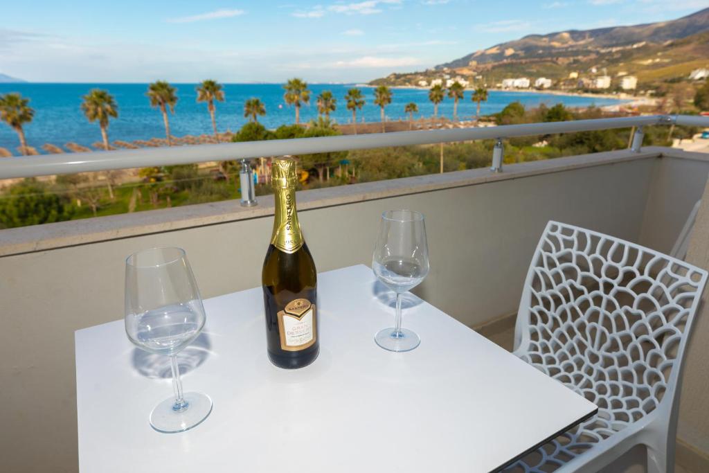 a bottle of wine on a table with two wine glasses at Seaview Apartments in Vlorë
