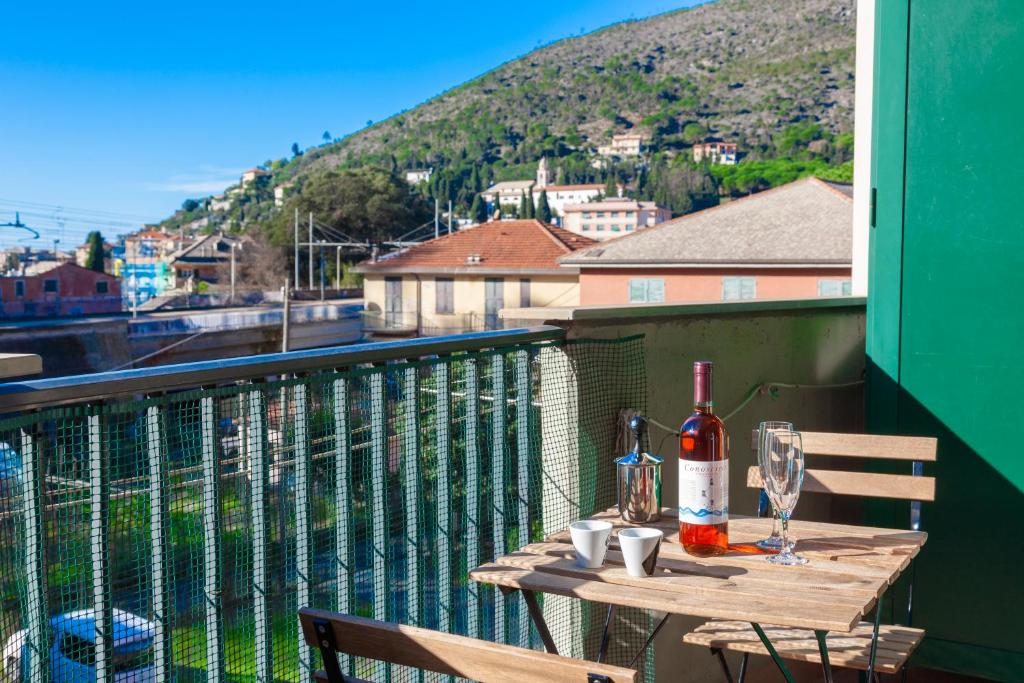 a table with a bottle of wine on a balcony at ANDREA Apartment in Levanto