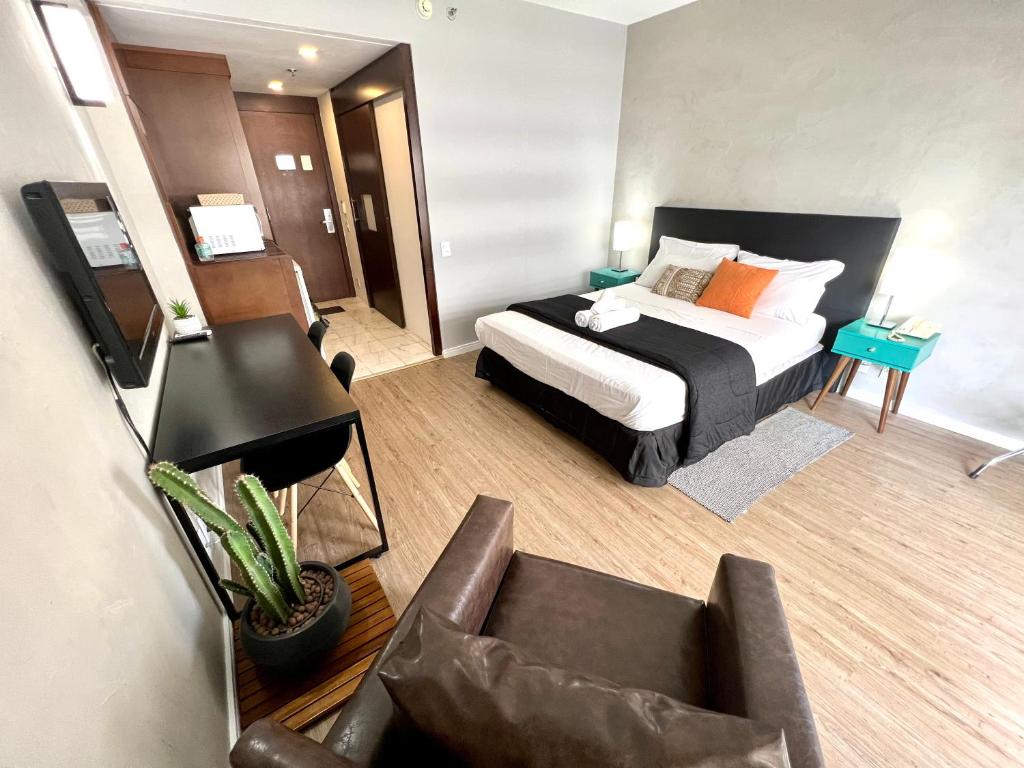 ein Schlafzimmer mit einem Bett und einem Stuhl in einem Zimmer in der Unterkunft Lindo Studio com Jacuzzi e sacada a 50m Av Paulista in São Paulo