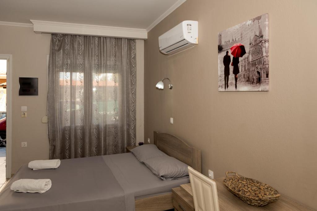 ケラモティにあるTzamtzis Apartmentsの小さなベッドルーム(ベッド1台、窓付)