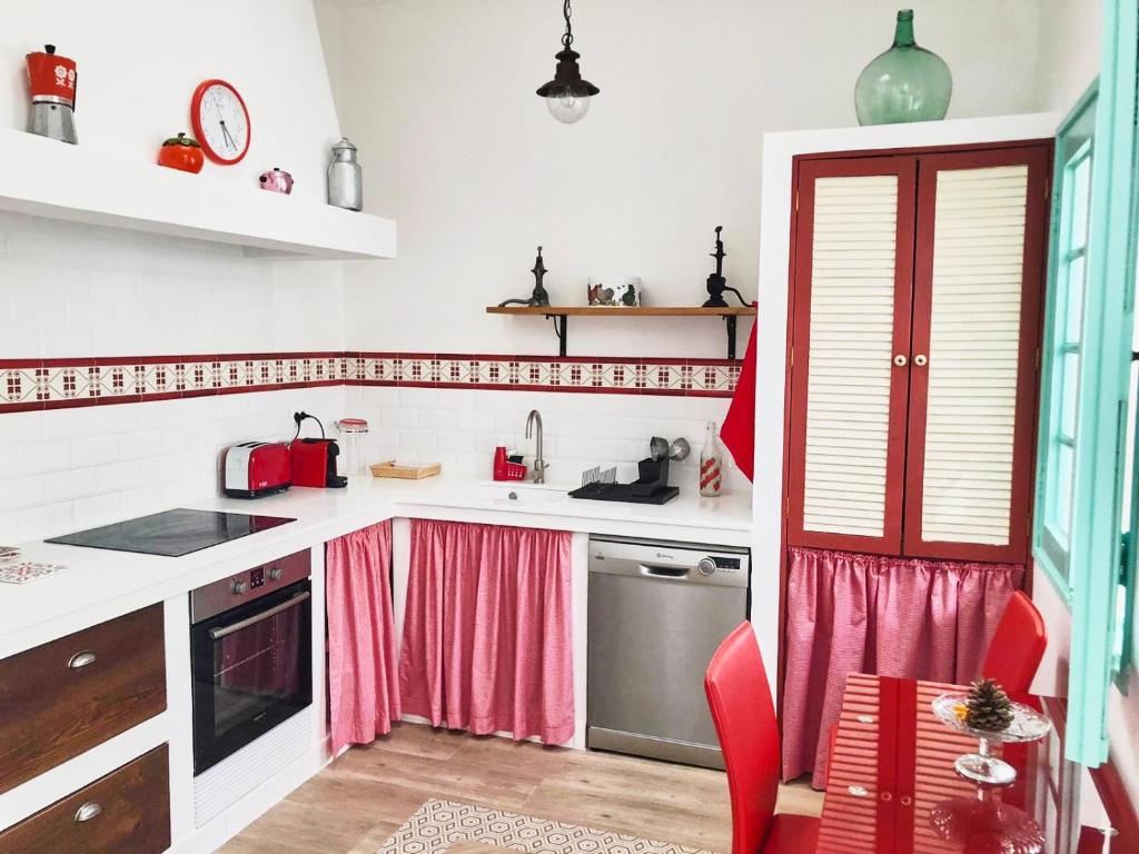 una cocina con encimeras blancas y cortinas rosas en Casa Las Enanitas I - Casa Leo en Fuencaliente de la Palma
