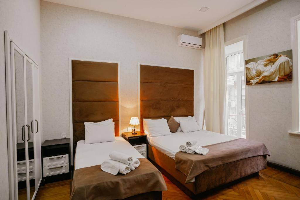 a hotel room with two beds with towels on them at City Inn Nizami Boutique Hotel in Baku