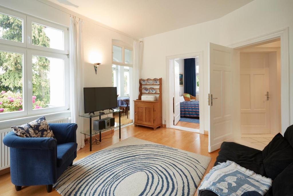 un salon avec un canapé bleu et une télévision dans l'établissement Villa Cremona Ferienwohnung 1, à Bansin