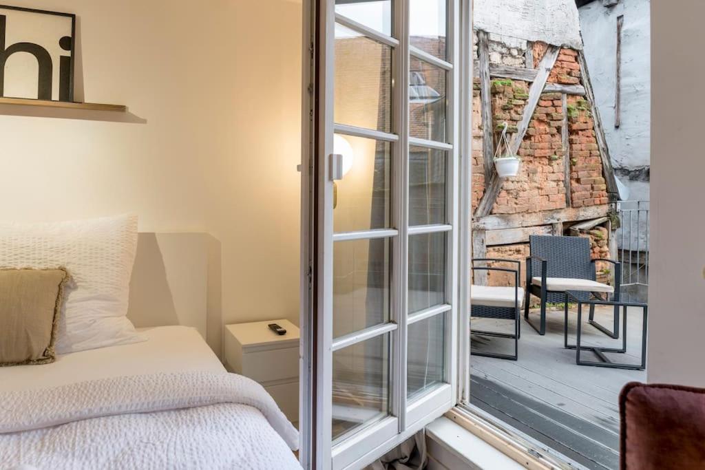a bedroom with a bed and a sliding glass door at Altstadt pur im Herzen Marburgs in Marburg an der Lahn