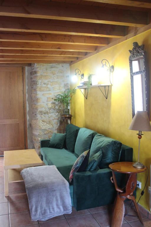 a living room with a green couch and a table at Errotazar apartamento rural K in Alsasua