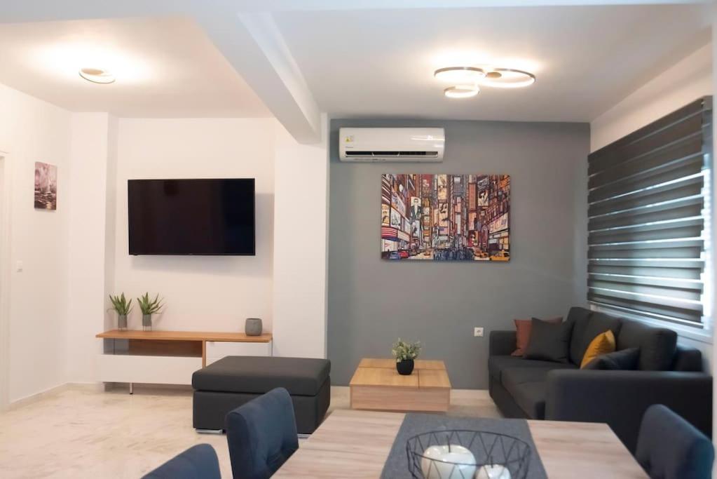 sala de estar con sofá y TV en Oniro Home en Ierápetra