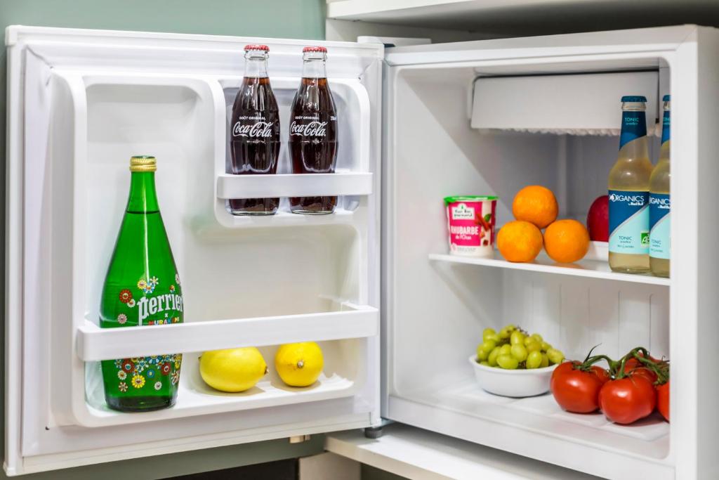 an open refrigerator with drinks and fruits and vegetables at Apartments WS Tour Eiffel - Laos in Paris